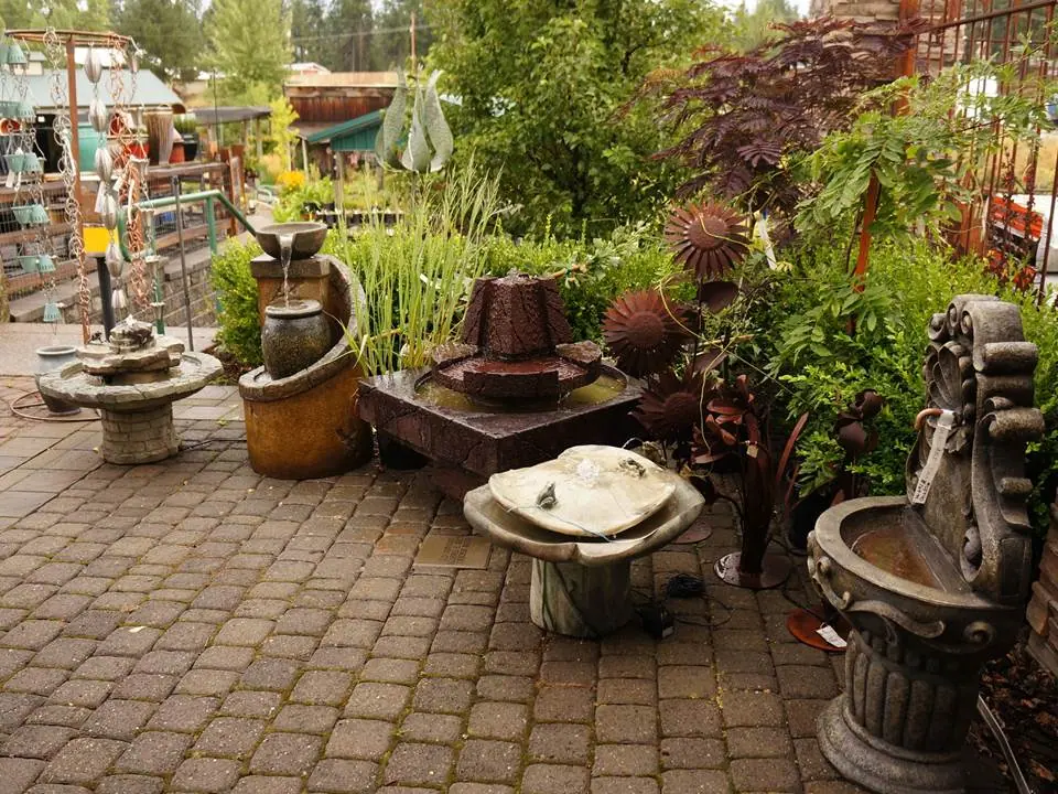 Garden fountains and large planters displayed along a brick path