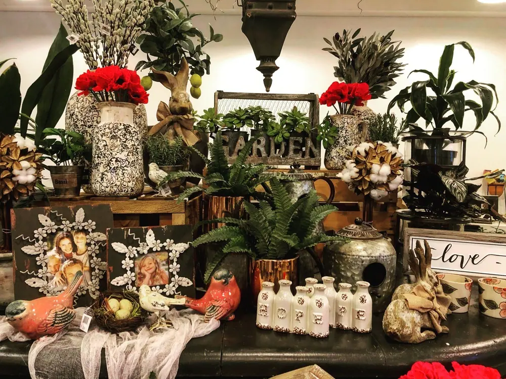 Indoor display of potted plants, decorative figures and garden gifts
