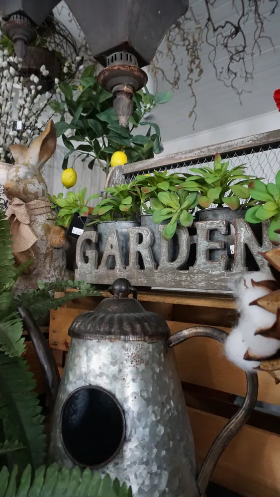 Garden sign and ornamental pots among indoor plants
